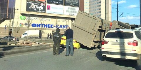 Мусорный контейнер упал с грузовика на такси в центре Москвы